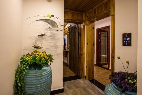 a hallway with two large blue vases with flowers at Chong Chong Guesthouse in Zhangjiajie