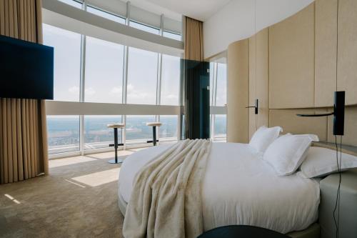 a bedroom with a large bed and a large window at Vilnius TV Tower Apartments DEBESYS in Vilnius