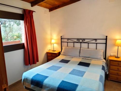ein Schlafzimmer mit einem blau-weißen Bett und einem Fenster in der Unterkunft Moixons in Calonge de Segarra