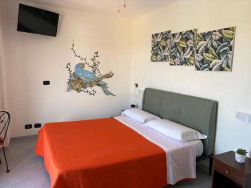 a bedroom with a bed with a red blanket and two paintings at Sunrise in Lascari