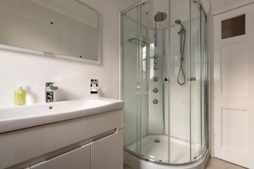 a bathroom with a glass shower and a sink at Avoncliffe in Crail