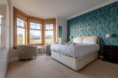 a bedroom with a bed and a blue wall at Avoncliffe in Crail