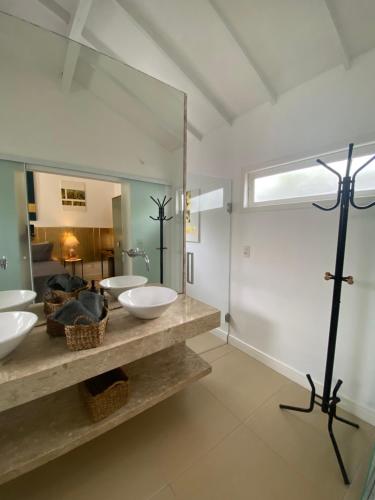 a bathroom with two sinks and a large mirror at Casa Mediterrânea Geribá in Búzios