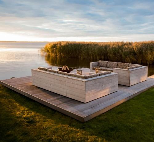 two boats sitting on a dock on a body of water at Ferienhaus Peeneblick - exklusives Traumhaus in Direktlage am Wasser mit Bootssteg und Aussensauna in Rankwitz