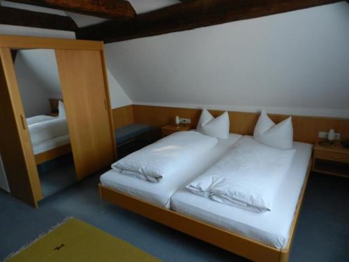 1 Schlafzimmer mit 2 Betten und einem Spiegel in der Unterkunft Gasthof Adler in Salem