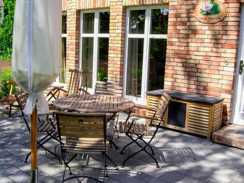 a patio with a table and chairs and a fireplace at Bauernkate Seerose in Liepe