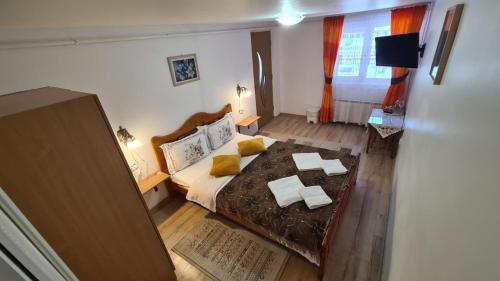 a bedroom with a large bed with yellow pillows at Casa Andrei in Slănic-Moldova