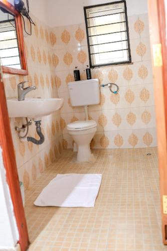a bathroom with a toilet and a sink at Cosy Garner Haven Watamu in Watamu