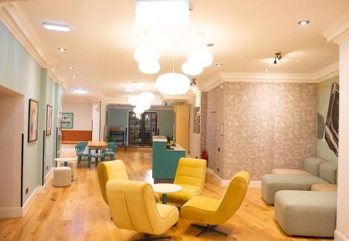 a lobby with yellow chairs and a table at Garner Hotel Reading City Centre, an IHG Hotel in Reading