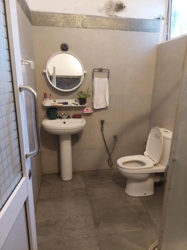 a bathroom with a toilet and a sink and a mirror at Sun Power Villa in Hokandara South