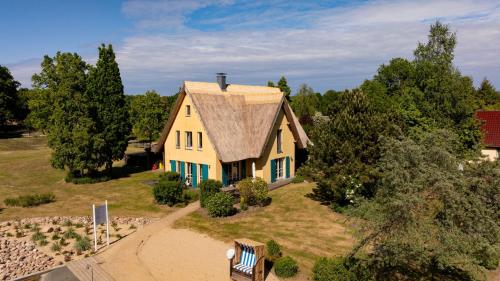 a small yellow house with a roof on a hill at Ferienhaus Kranich in Krienke