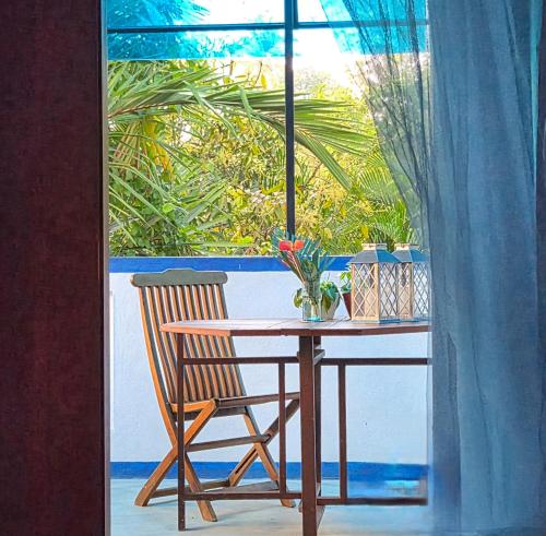 a wooden table with a chair and a window at Nelum Vegan House in Bentota
