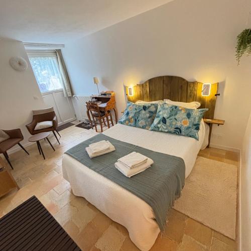 a bedroom with a large bed with two towels on it at La Balastière in Beaumont-en-Véron