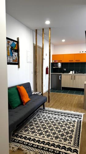 a living room with a couch and a kitchen at S'apartments New in Leiria