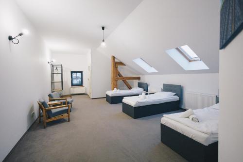 a room with two beds and a chair in it at Folwark Matecznik - Dworek in Sęzinko
