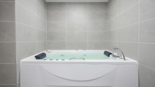 a bath tub with a faucet in a bathroom at Gapyeong Haneulsup Spa Pension in Gapyeong