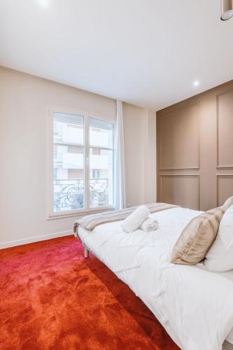 a bedroom with a large bed and a large window at Suite Cognac - International Palace - Jacuzzi in Vichy