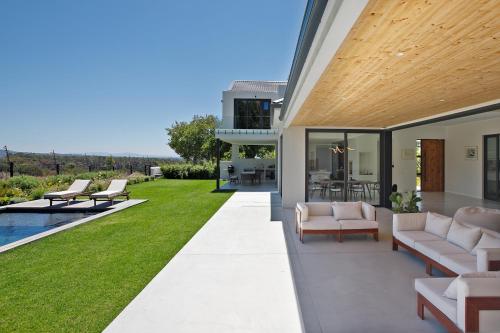 a modern house with a patio and a yard at Table Mountain Constantiaberg view in Sweet Valley