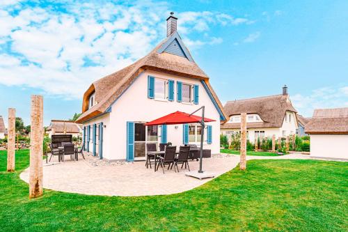 a house with a thatched roof and a patio at Kramerhof Ferienhaus Luv und Lee in Parow