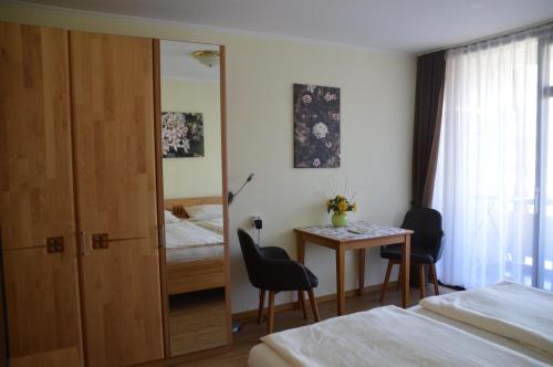 a hotel room with a table and a bedroom at Chalet Swiss - App.Nelles in Bad Füssing