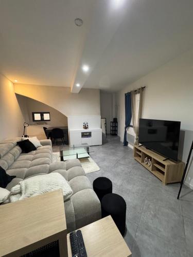 a living room with a couch and a flat screen tv at Blue house in Saint-Gilles