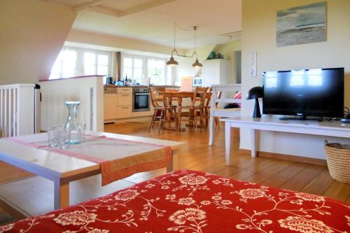 a kitchen and living room with a television and a table at Midlum- Peppin, OG in Midlum