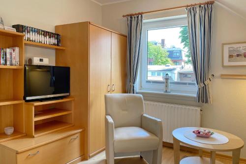 a living room with a tv and a chair and a table at MS Störtebecker, Sandwall in Wyk auf Föhr
