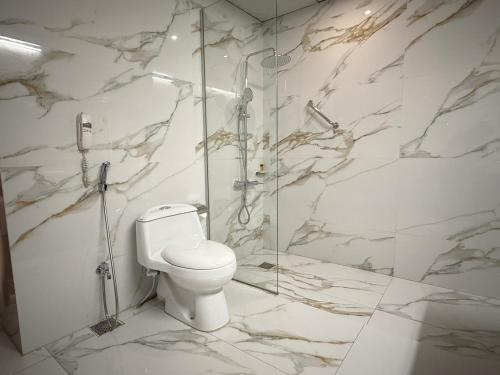 a bathroom with a toilet and a glass shower at Indus Hotel Hyderabad in Hyderabad