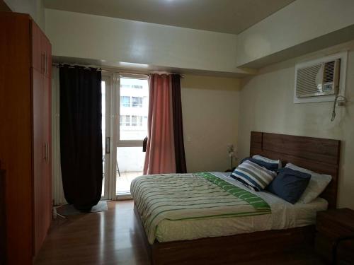 a bedroom with a bed and a large window at Celadon Tower- Studio with balcony near SM San Lazaro in Manila