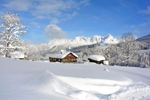 a house covered in snow in front of a mountain at Göglgut in Lungötz