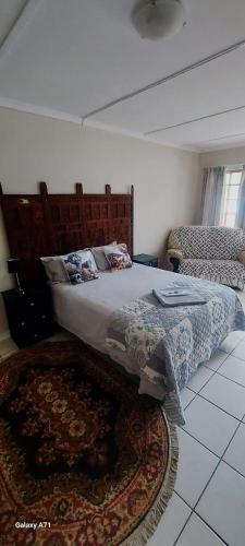 a bedroom with a large bed and a rug at Karoo House Guesthouse in Somerset East