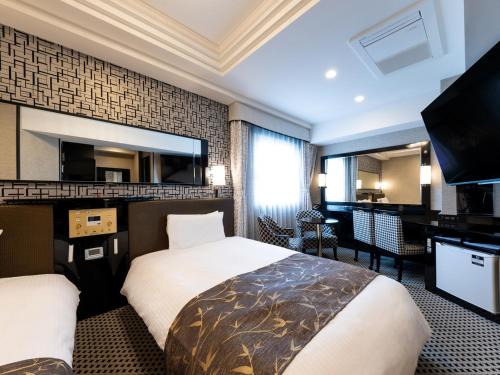a hotel room with a bed and a flat screen tv at APA Hotel Nishifunabashi Ekimae in Funabashi