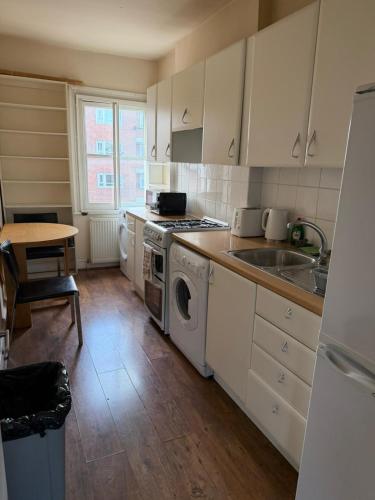 a kitchen with a sink and a stove top oven at Rooms in Islington in London