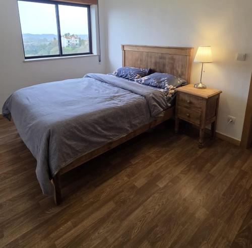 a bedroom with a bed and a table with a lamp at MM Apartamento com Quarto privado Com árias in Coimbra