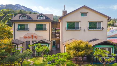 a large white building with trees in front of it at Gapyeong Maplein Pension in Pocheon