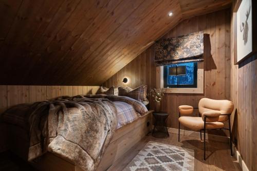 a bedroom with a large bed and a chair at FJELLRO Private Alpine Lodge Høgevarde in Flå
