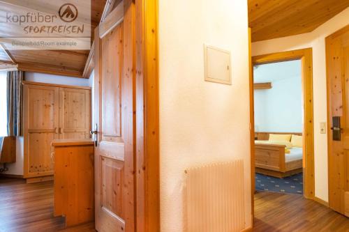 a room with wooden walls and a room with a bed at Apart Furcletta in Ischgl