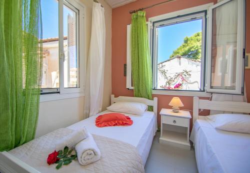 two beds in a small room with a window at Dora's Beach Cottages in Planos