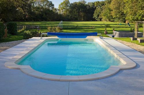 a large swimming pool in the middle of a yard at La Bonne Vie Gite in Chaunay