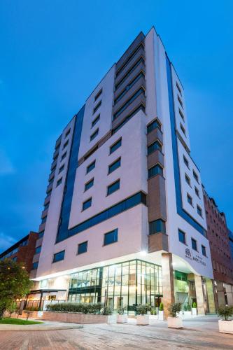 a large white building with glass windows at Hotel Andes Plaza in Bogotá