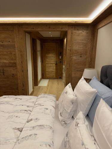 a bedroom with a bed with white sheets and pillows at Petite Fraise in Gstaad