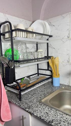 a kitchen counter with plates and utensils on a shelf at Manja Homes in Ruiru