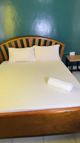 a bed with a wooden head board with a pillow on it at Manja Homes in Ruiru