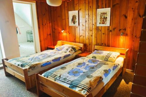 two beds in a room with wood paneling at holiday home with thatched roof, Rekowo in Rekowo
