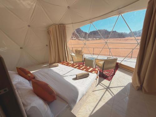 a bed in a tent with a view of a desert at Hasan Zawaideh Camp in Wadi Rum