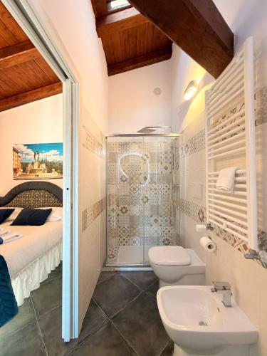 a bathroom with a shower and a toilet and a sink at MECE Rooms in LʼAquila