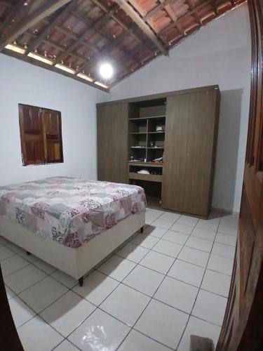 a bedroom with a bed and a wooden cabinet at Férias da Hora in Prado