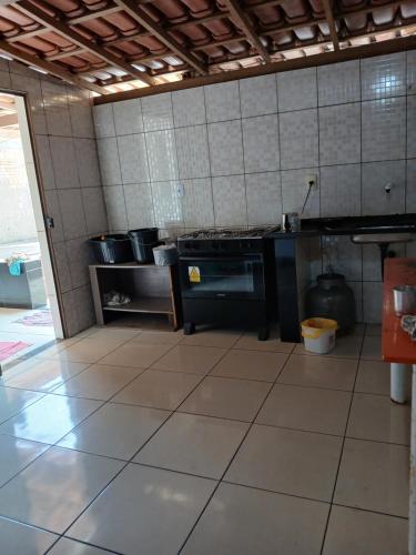 a kitchen with a stove and a tiled floor at Férias da Hora in Prado