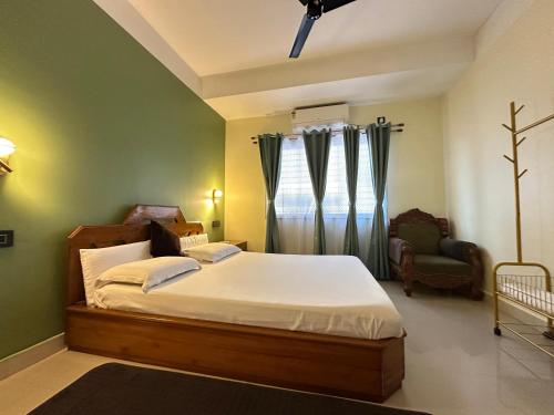 a bedroom with a bed and a chair at Zen Luxe Abode in Siliguri