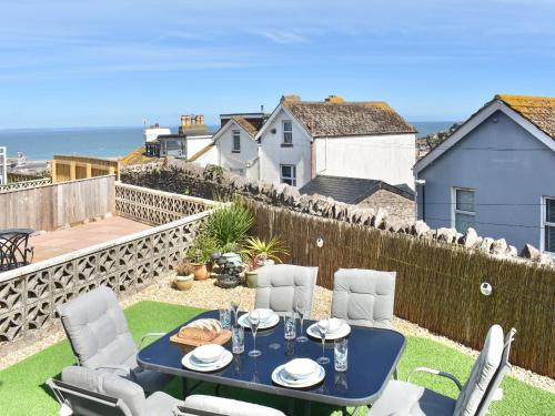 a patio with a table and chairs and the ocean at Seagulls View in Brixham